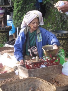Old lady weighing ginger.
