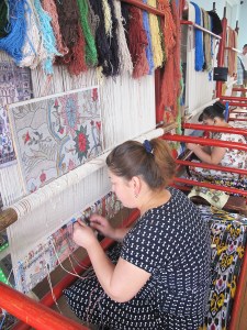 Lady working on an original design on silk carpet made with naturally dyed silk threads.