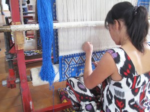 Lady working on a classic design on silk carpet made with naturally dyed silk threads.