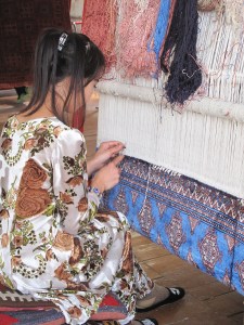 Lady working on an original design on silk carpet made with naturally dyed silk threads.